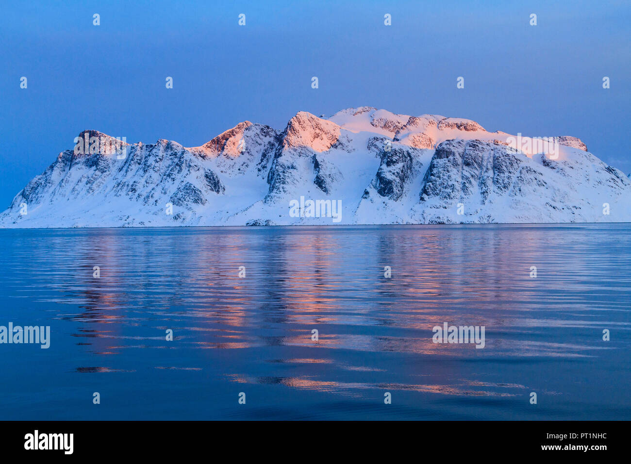 Snowcapped peaks at sunset on a fjord of Greenland, Arctic sea, Denmark Stock Photo