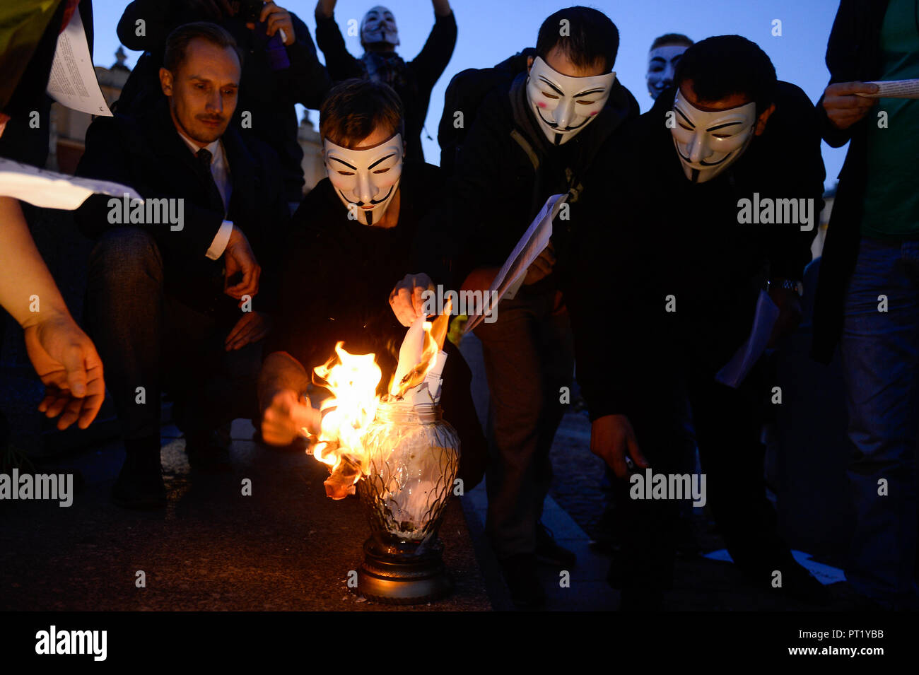 Krakow, Poland. 5th Oct, 2018. Protesters with Guy Fawkes masks seen burning the European Commission Copyright Directive during the demonstration.Protest against the implemented EU Copyright Directive (known as ACTA 2.0) in front of Adam Mickiewicz Monument at the Main Square. On September 12, 2018 an updated version of the controversial articles 11 and 13 of the Directive on Copyright in the Digital Single Market were approved by the European Parliament. EU claims that article 11 and 13 aim to protect the copyrights and to bring profits to news outlets, artists and others when social med Cred Stock Photo