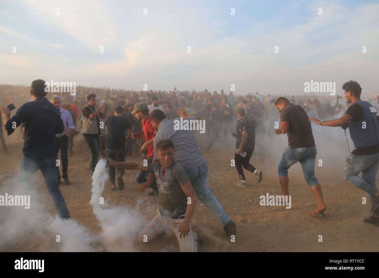 October 5, 2018 - Al-Buraj Refugee Camp, The Gaza Strip, Palestine - Palestinian protesters set fire to tires and throw rocks, while Israeli forces opened live fire and tear-gas bombs east of Al-Buraj refugee camp in central of the Gaza Strip, Two Palestinians killed and dozens wounded during clashes between Palestinians and Israeli troops. Credit: Mahmoud Khattab/Quds Net News/ZUMA Wire/Alamy Live News Stock Photo