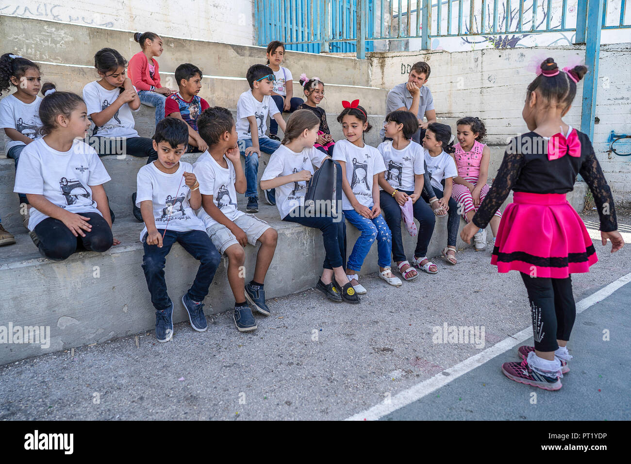 Bethlehem, Palestine. 16th Feb, 2018. Tolay seen singing to her classmates from outside the sports recreation area of the school during the summer camp.The Return Summer Camp was organised for children of the Aida refugee camp, it was established in 1950 by the Palestinians who were expelled from their homes from 27 towns throughout Palestine, namely Nasra, Tabaria, Jerusalem, Acre, Jaffa, Haifa and Hebron. This is a 4th generation of refugees, 130 children ranging from 4 to 16 years of age being overlooked by 20 instructors and volunteers and it was funded by the UN until 2000. (Credit Stock Photo