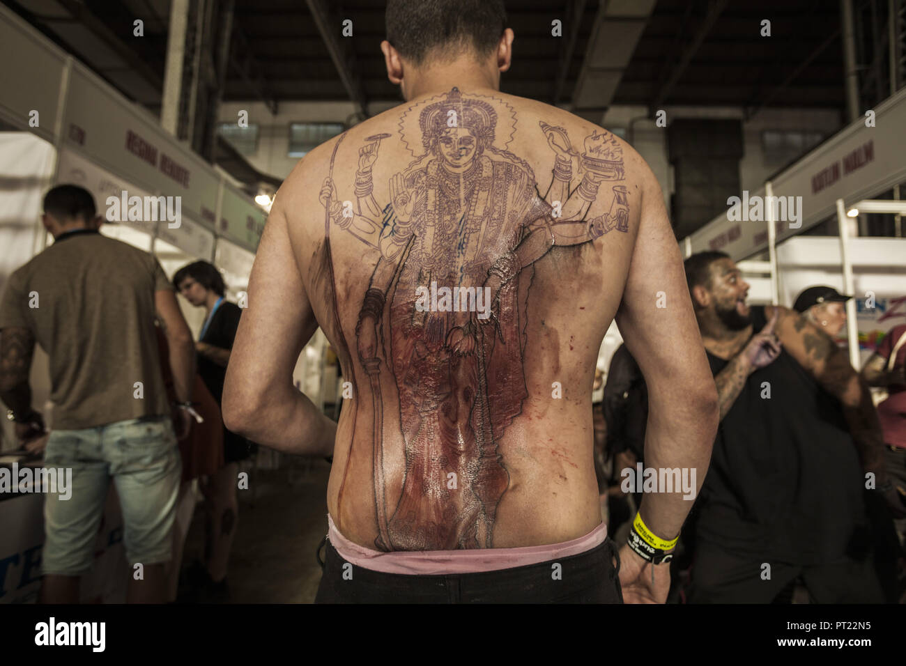 Barcelona, Catalonia, Spain. 5th Oct, 2018. Man shows his back during the process of tattooing in the 21st tattoo and urban culture Expo in Barcelona. Credit: Celestino Arce Lavin/ZUMA Wire/Alamy Live News Stock Photo