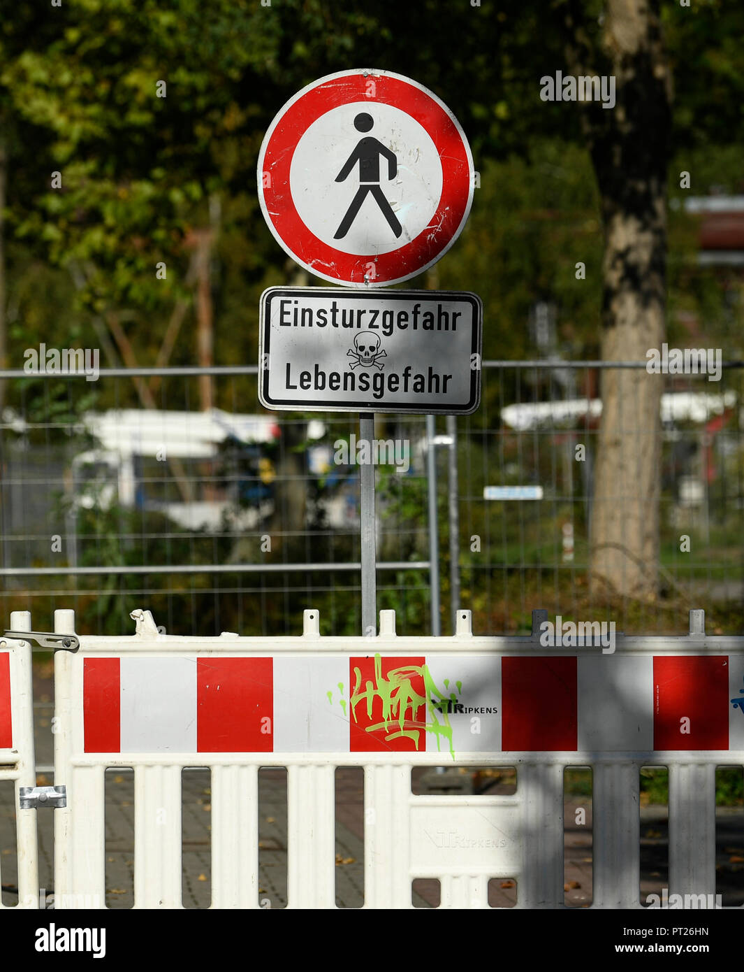 06 October 2018, North Rhine-Westphalia, Dortmund: A sign reading 'Einsturzgefahr Lebensgefahr' ('Fall risk - Lethal risk') in front of a barrier along the sunken Emscherallee in the Huckarde district. The road continued to sag yesterday for several meters and is now closed for 150 meters. A large detour has been set up. Photo: Ina Fassbender/dpa Stock Photo