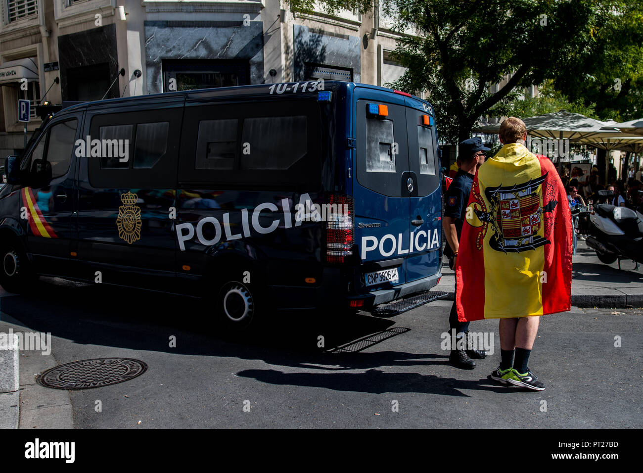 Madrid, Spain. 6th October, 2018. A man with a a francoist flag speaking with police during a demonstration demanding resignation of President Pedro Sanchez and calling for the union of Spain in the independence process of Catalonia, in Madrid, Spain. Credit: Marcos del Mazo/Alamy Live News Stock Photo