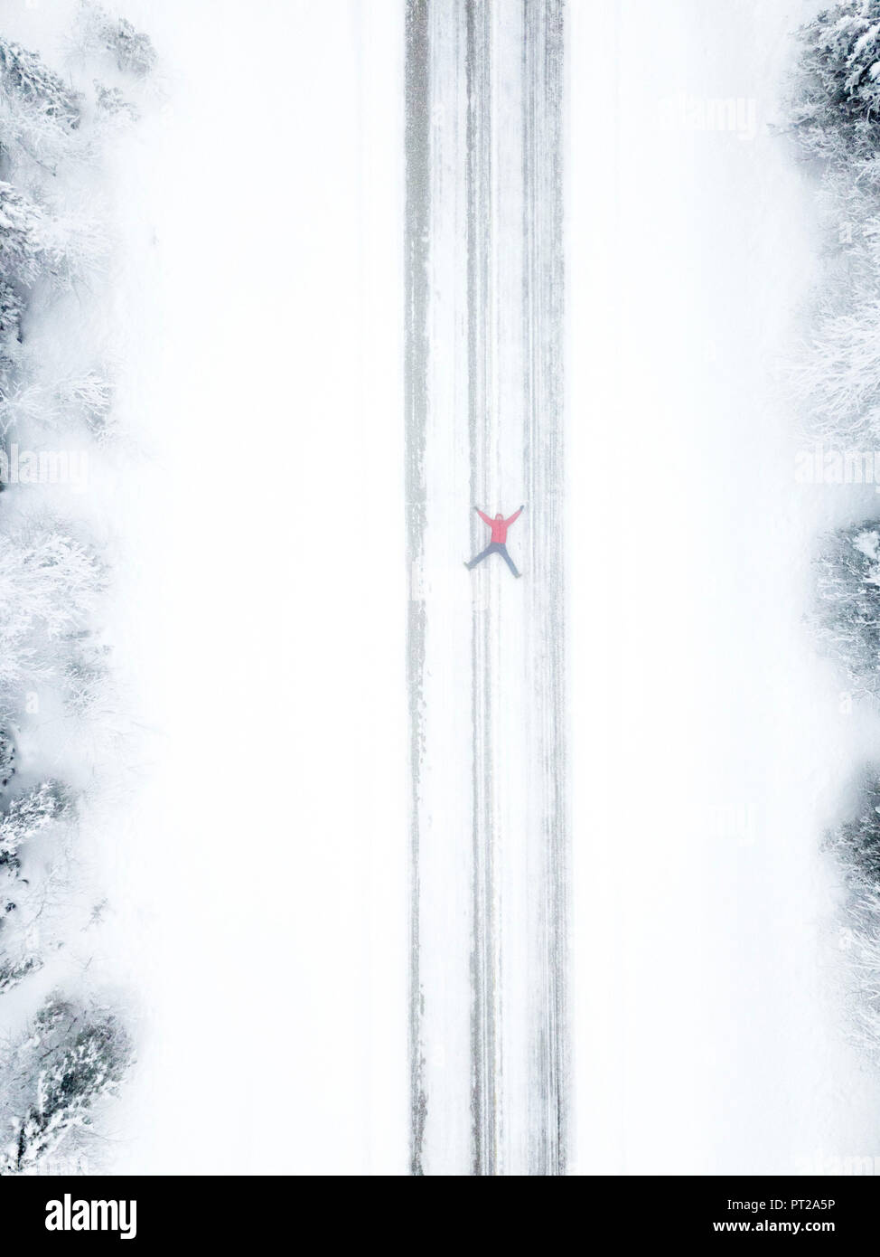 Aerial view of person lying down on snowy road, Pallas-Yllastunturi National Park, Muonio, Lapland, Finland Stock Photo