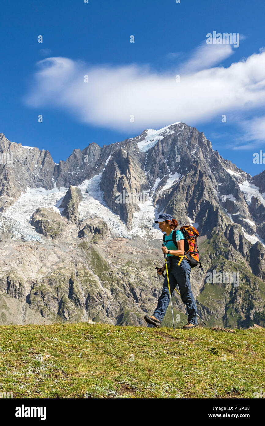 A trekker is walking in front of the Grandes Jorasses during the Mont Blanc hiking tours (Ferret Valley, Courmayeur, Aosta province, Aosta Valley, Italy, Europe) Stock Photo