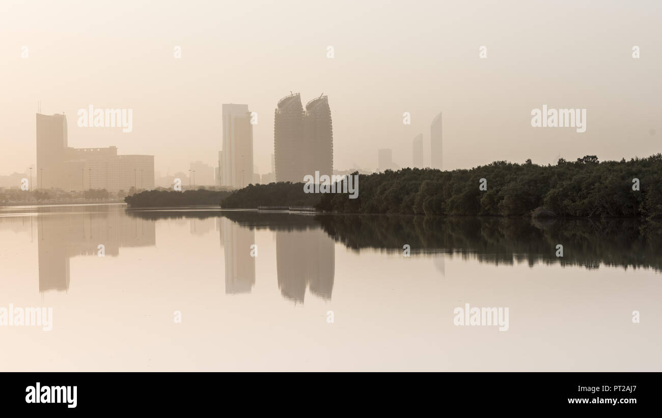 27 August 2018: Al Bahr Towers and Mangroves reflection in the sea, Abu Dhabi UAE Stock Photo