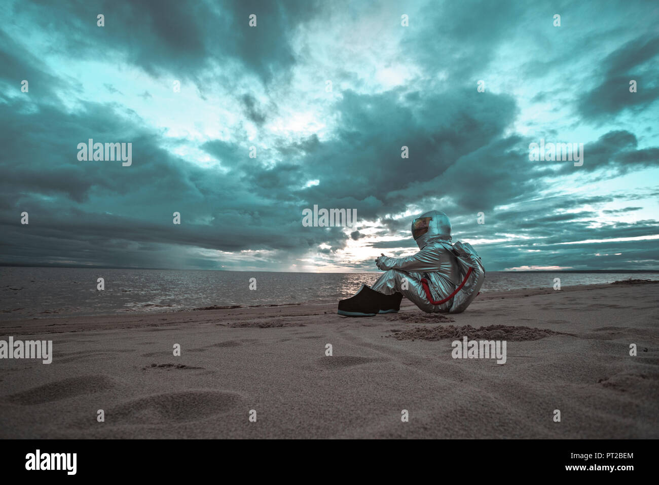 Lonely spaceman looking at lake on nameless planet Stock Photo