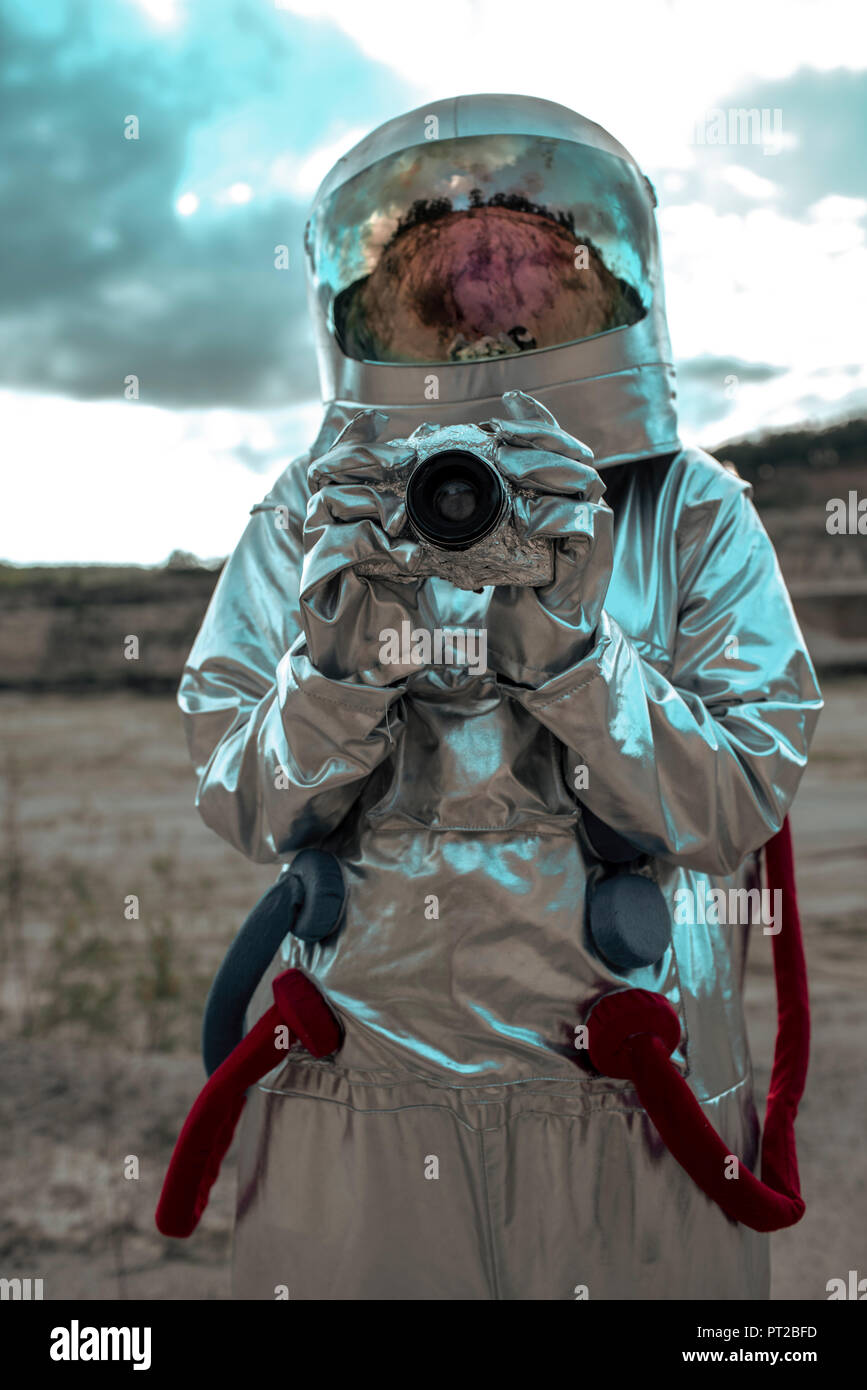 Spaceman on nameless planet taking pictures with camera Stock Photo