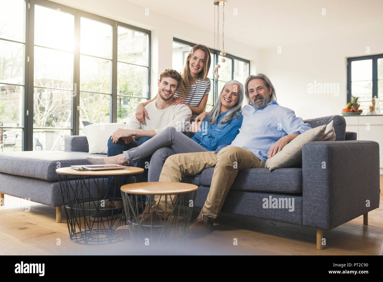 Senior couple with family sitting on couch Stock Photo