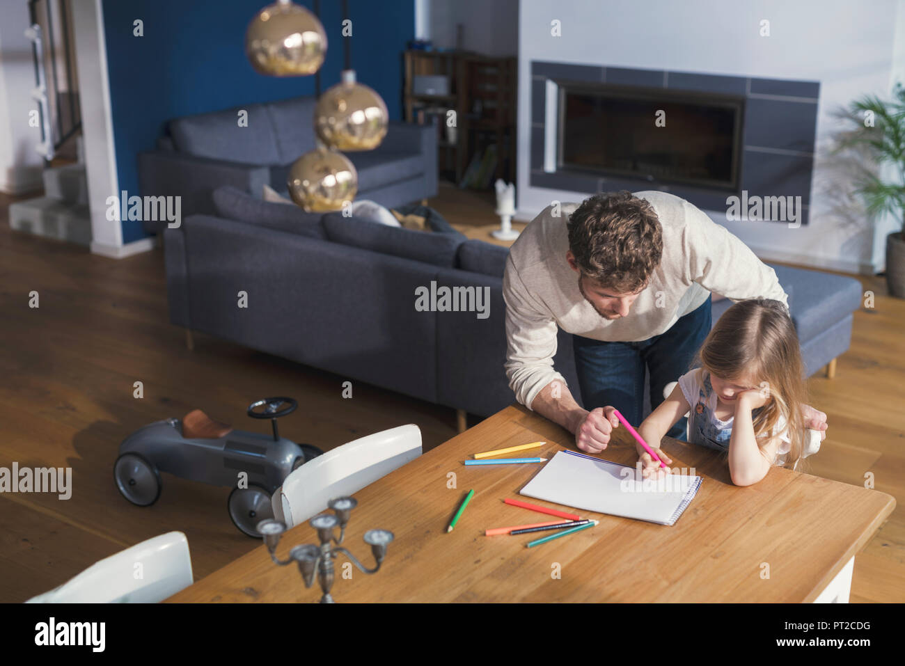 Father helping his daughter to make a drawing Stock Photo