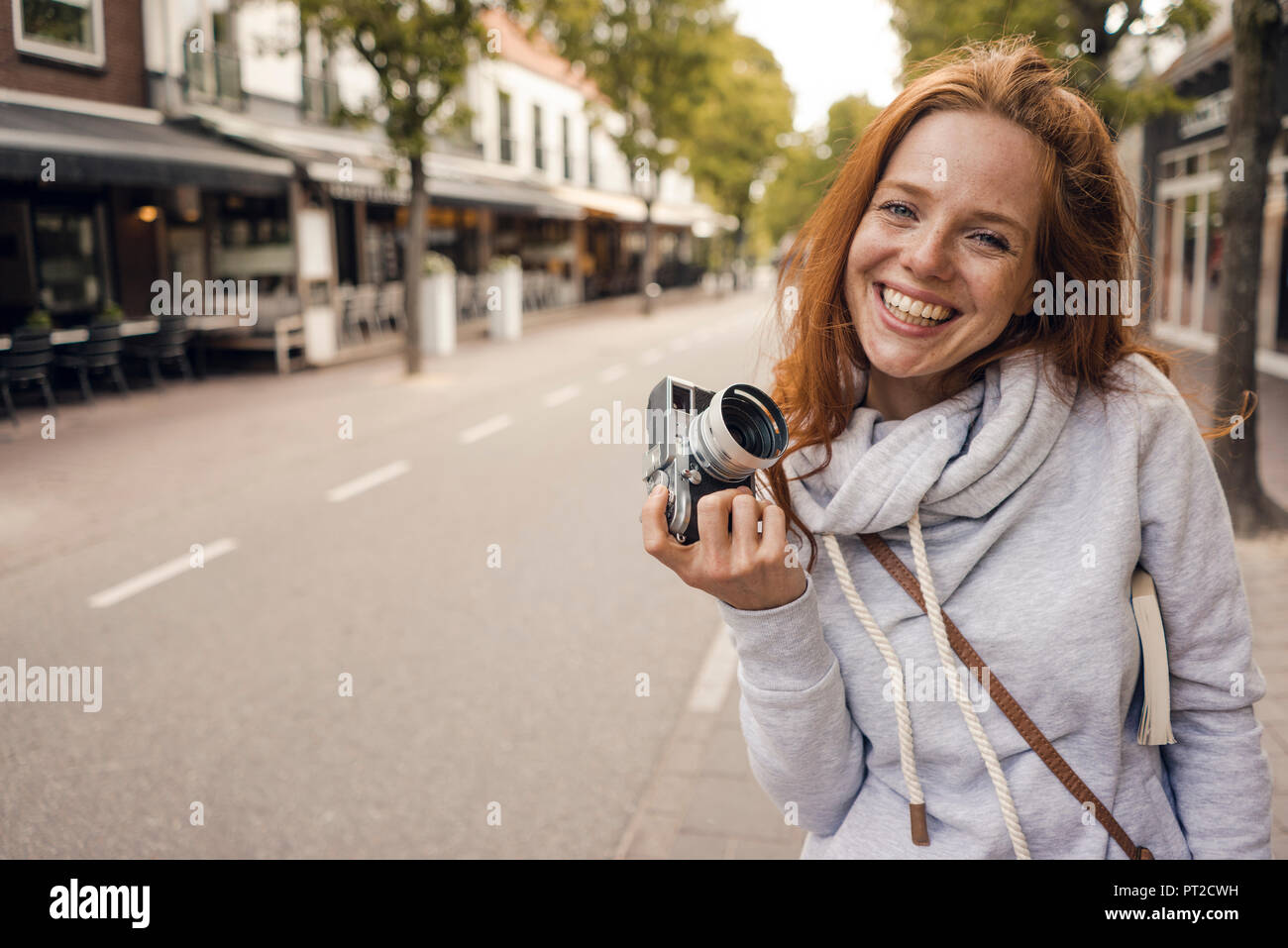 Redheaded woman using analogue camera Stock Photo