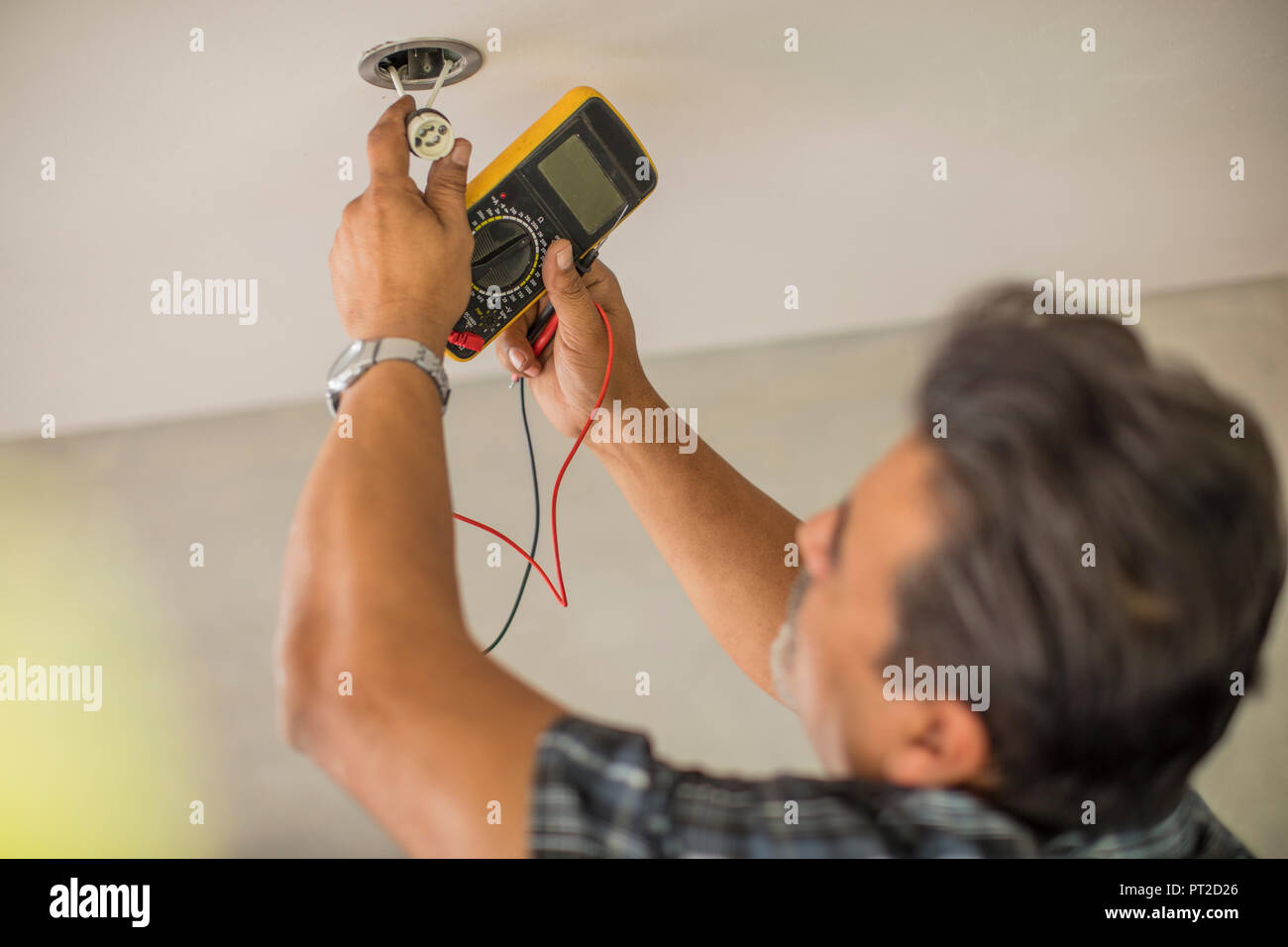 Man checking electric current of light Stock Photo