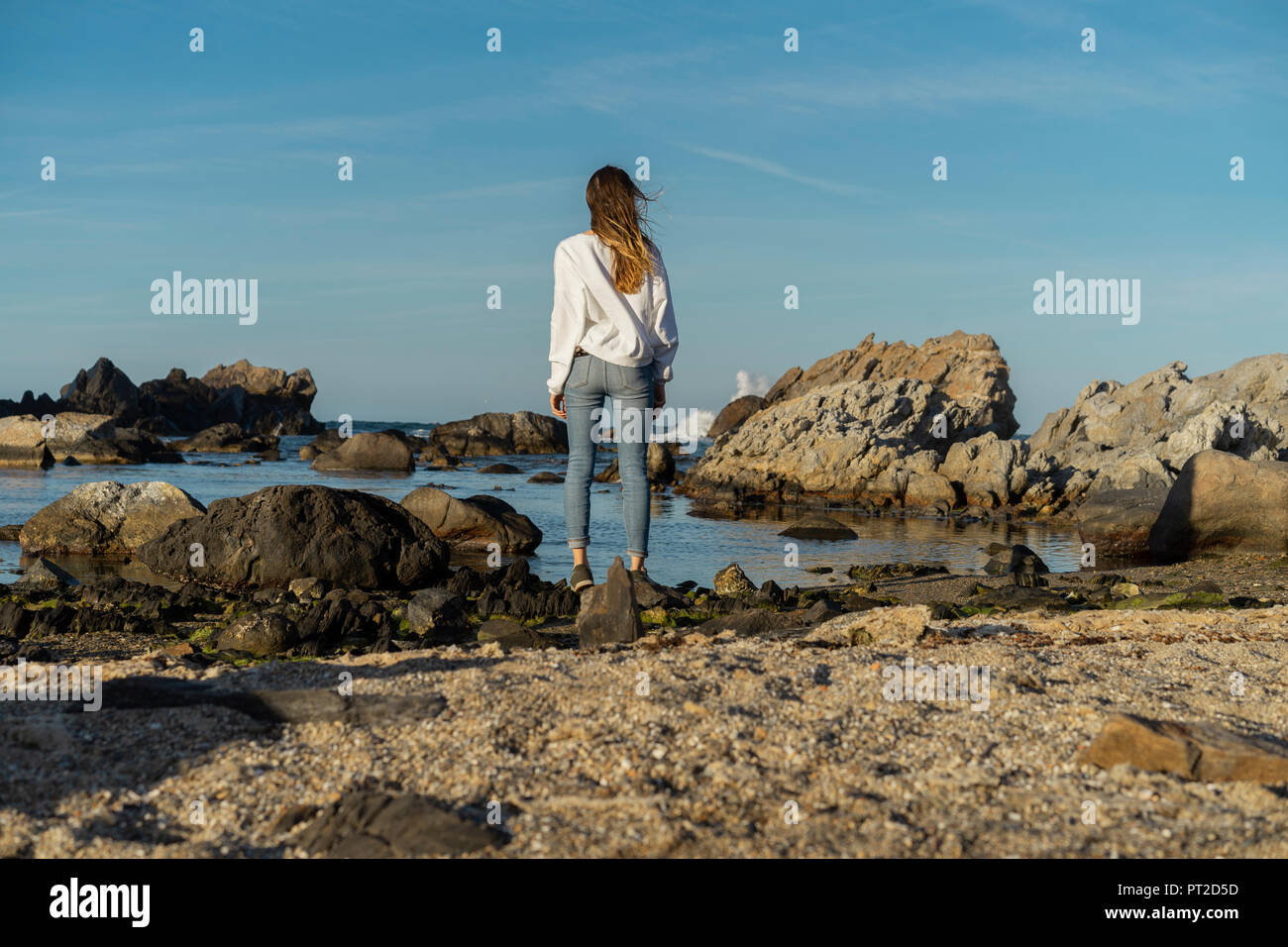 Girl Looking Over Rocks Back woman sitting rock looking view hi-res stock photography and ...