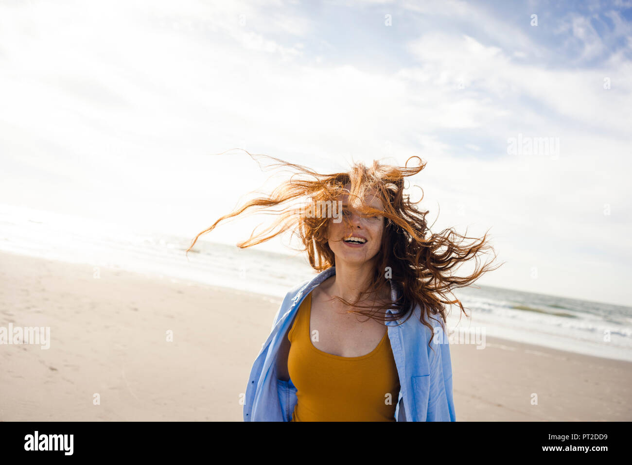 Portrait of a redheaded woman, laughing happily on the beach Stock Photo