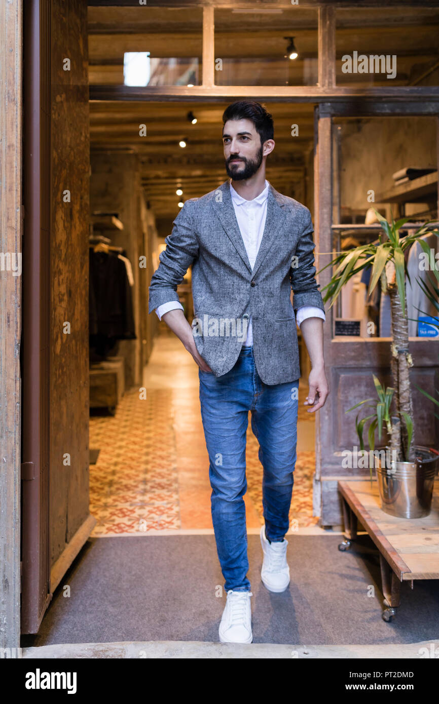 Confident man wearing jacket leaving menswear shop Stock Photo - Alamy