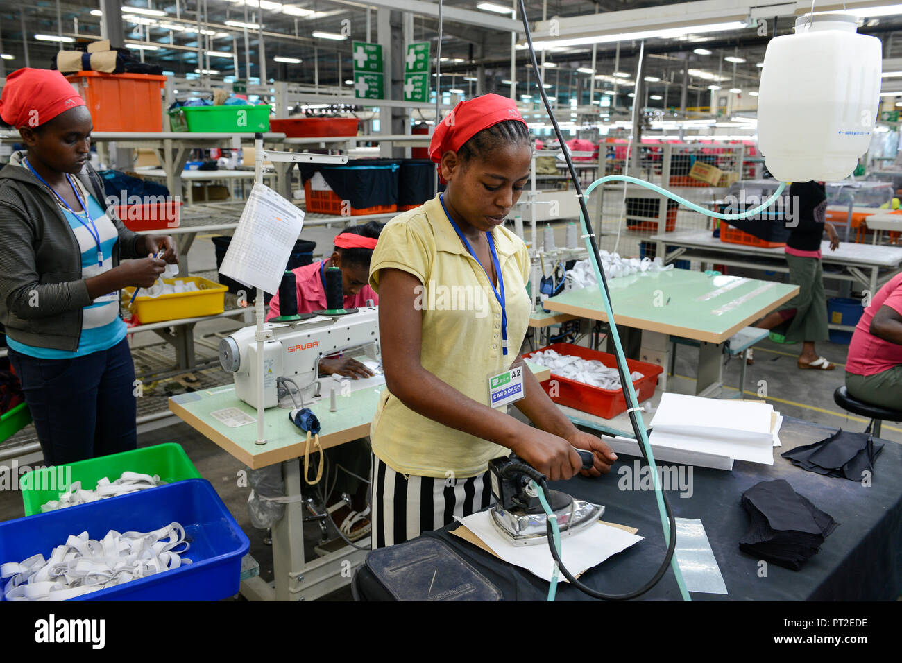 ETHIOPIA , Southern Nations, Hawassa or Awasa, Hawassa Industrial Park, chinese-built for the ethiopian government to attract foreign investors with low rent and tax free to establish a textile industry and create thousands of new jobs, taiwanese company Everest Textile Co. Ltd.produces textiles from synthetic fabric for export, woman ironing cloth pieces with iron Stock Photo