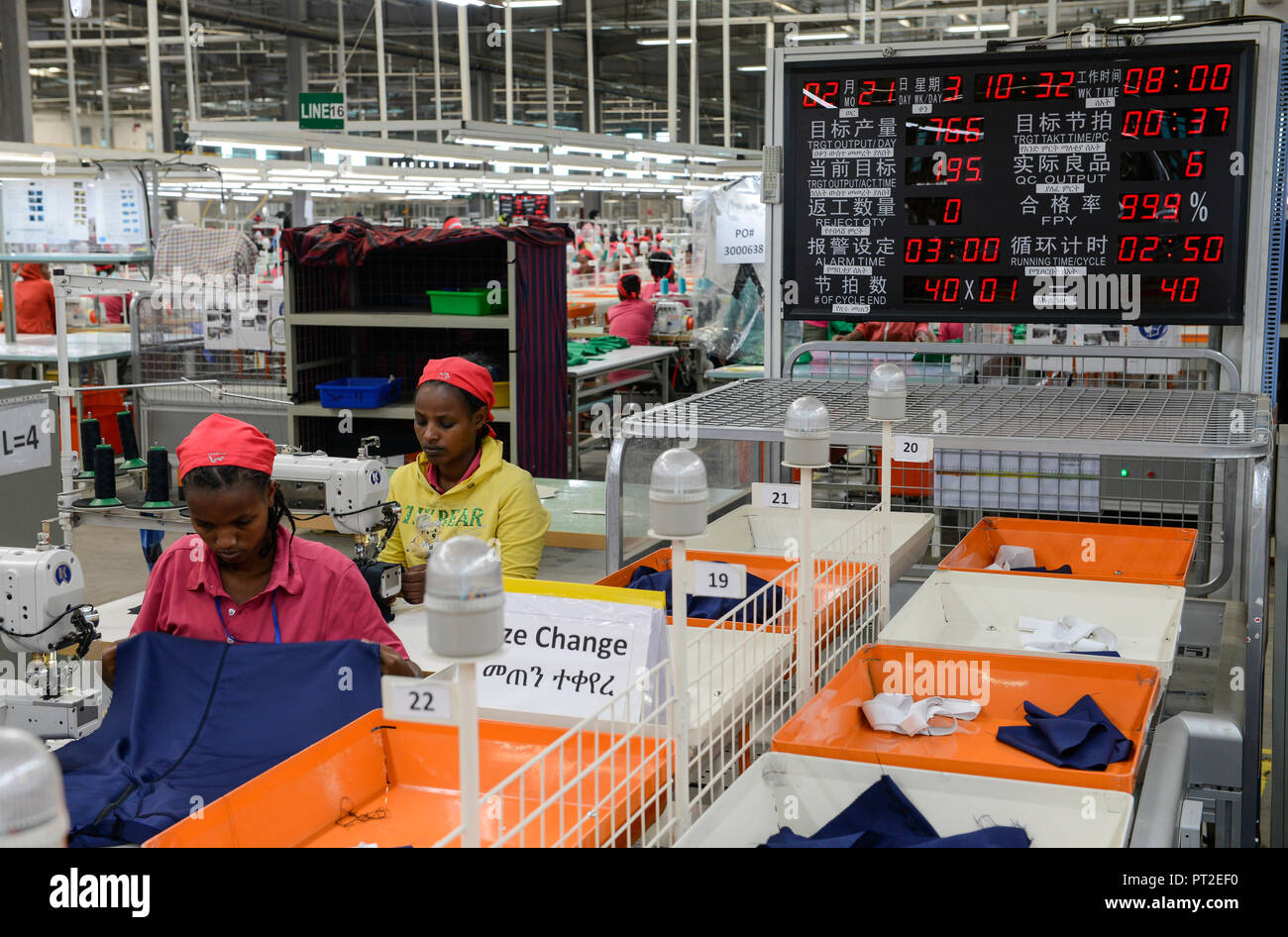 ETHIOPIA , Southern Nations, Hawassa or Awasa, Hawassa Industrial Park, chinese-built for the ethiopian government to attract foreign investors with low rent and tax free to establish a textile industry and create thousands of new jobs, taiwanese company Everest Textile Co. Ltd.produces textiles from synthetic fabric for export, women at sewing machine in production line and Performance and efficiency display Stock Photo