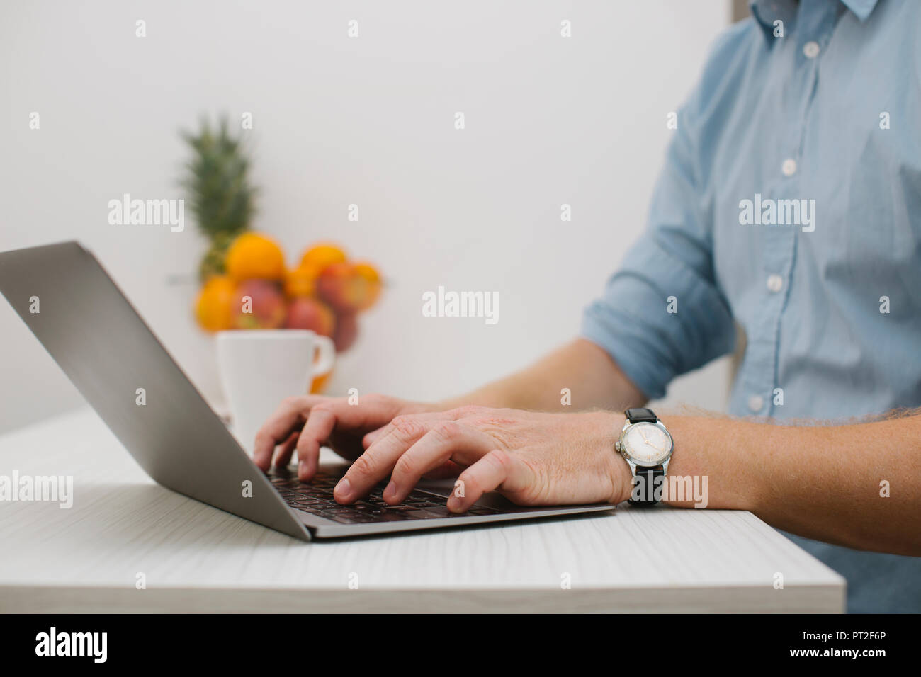 Businessman working on his laptop at home, partial view Stock Photo