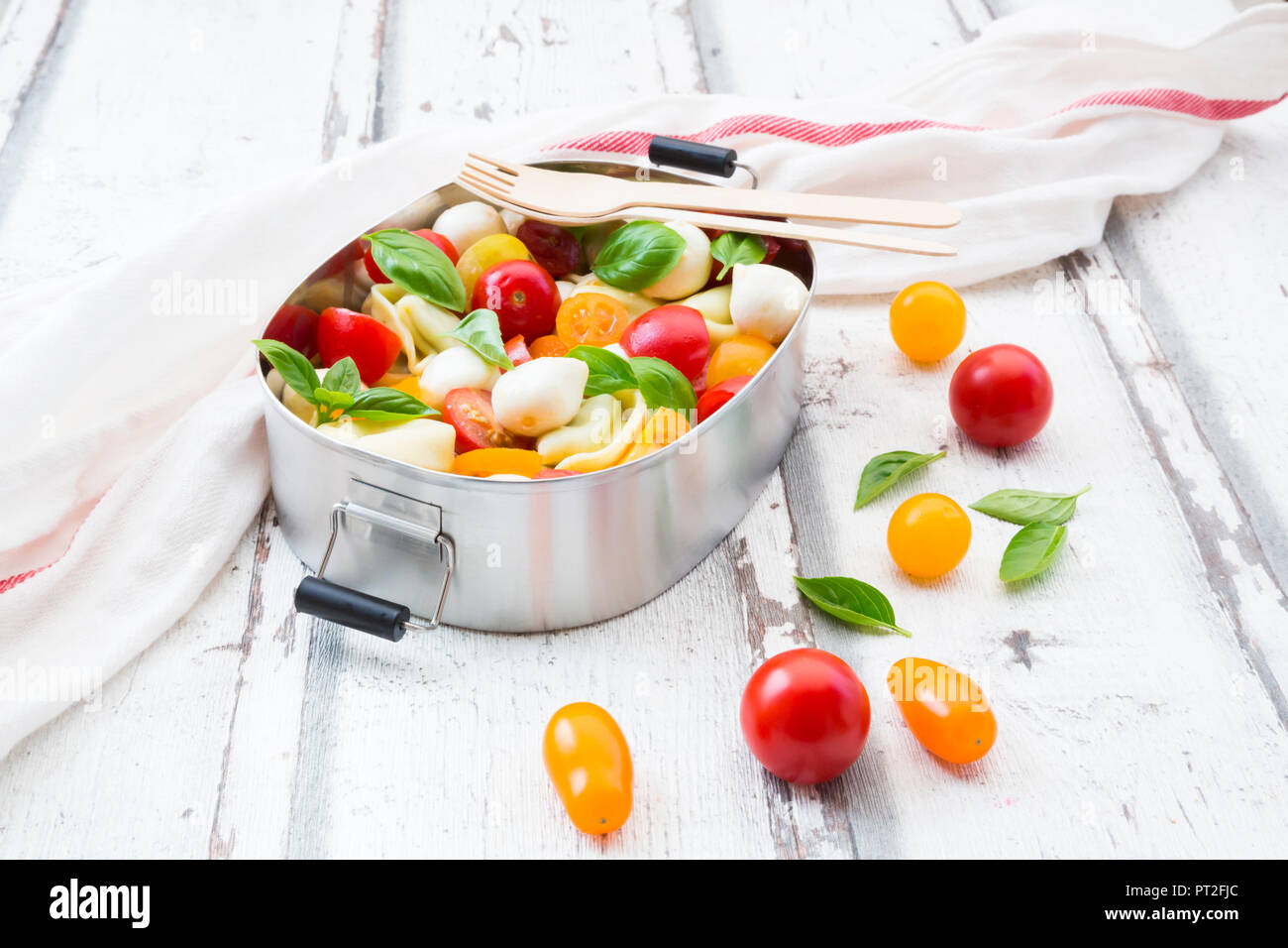 Tortellini salad with tomato, mozzarella and basil in lunch box Stock