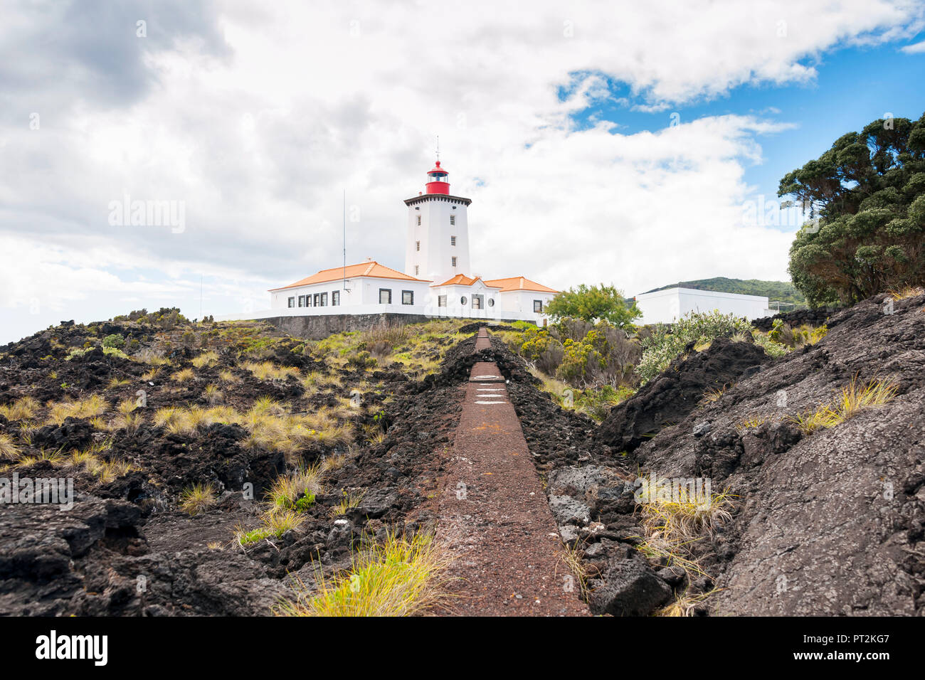Lighthouse of Piedade on rocky shore built on lava rock Stock Photo