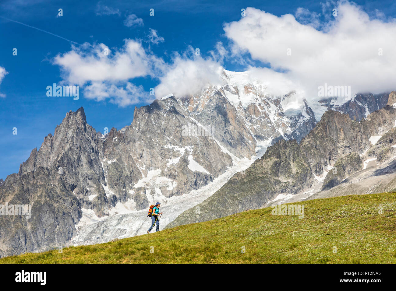 A trekker is walking in front of the Mont Blanc during the Mont Blanc hiking tours (Ferret Valley, Courmayeur, Aosta province, Aosta Valley, Italy, Europe) Stock Photo