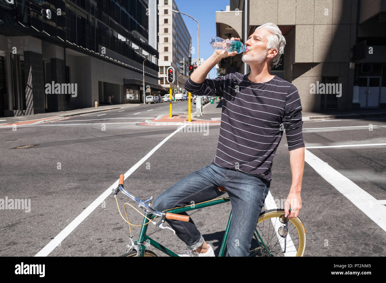Man on bicycle drinking water Stock Photo