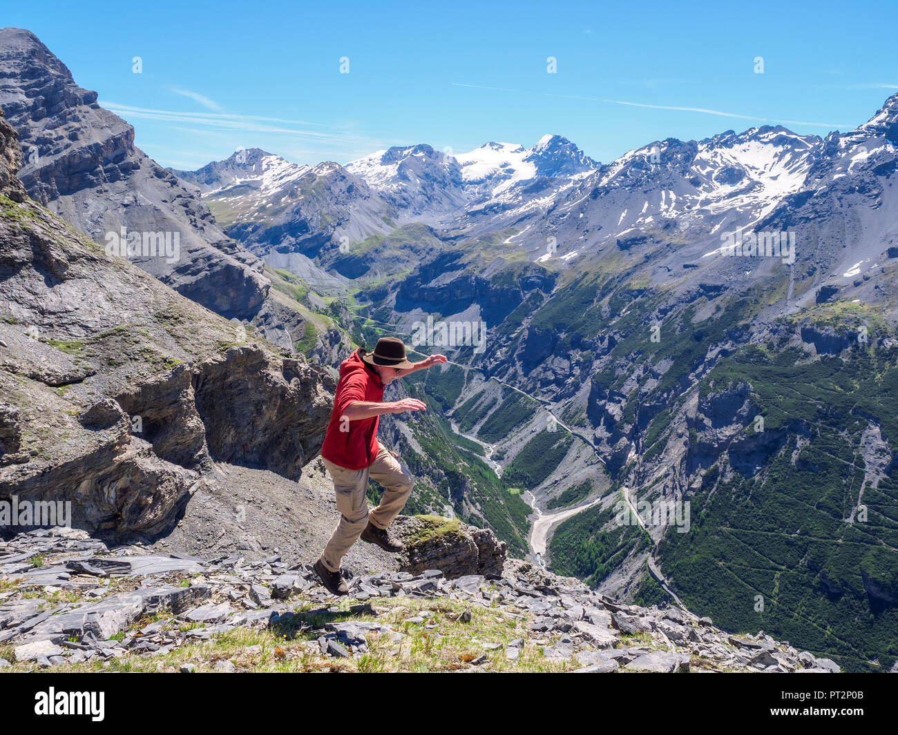 Italy, Lombardy, Sondrio, hiker jumping with view to Stelvio Pass and Ortler Stock Photo