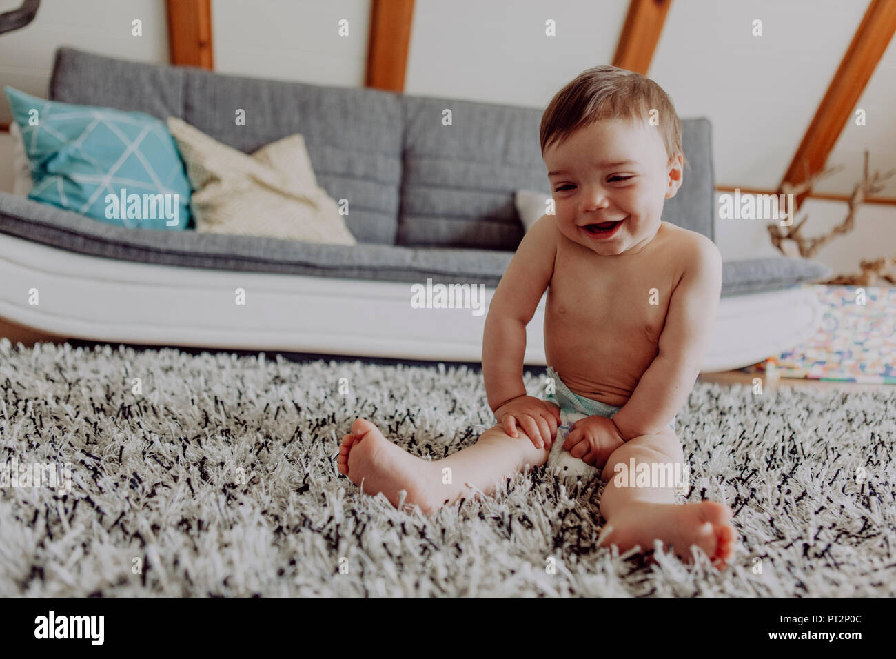 Happy baby playing on carpet Stock Photo - Alamy