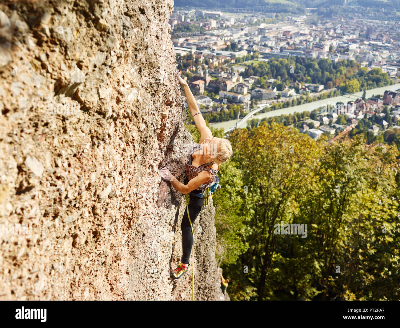 Austria, Innsbruck, Hoettingen quarry, woman climbing in rock wall Stock Photo