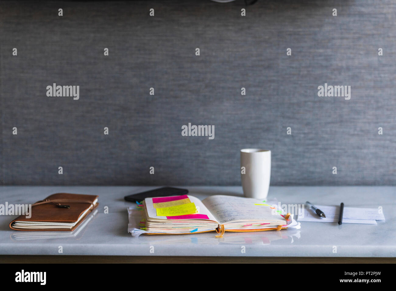 Notebooks, pen and coffee cup on shelf Stock Photo