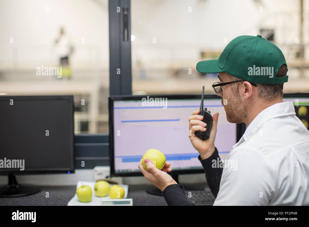 Worker using walkie talkie while working at computer Stock Photo ...