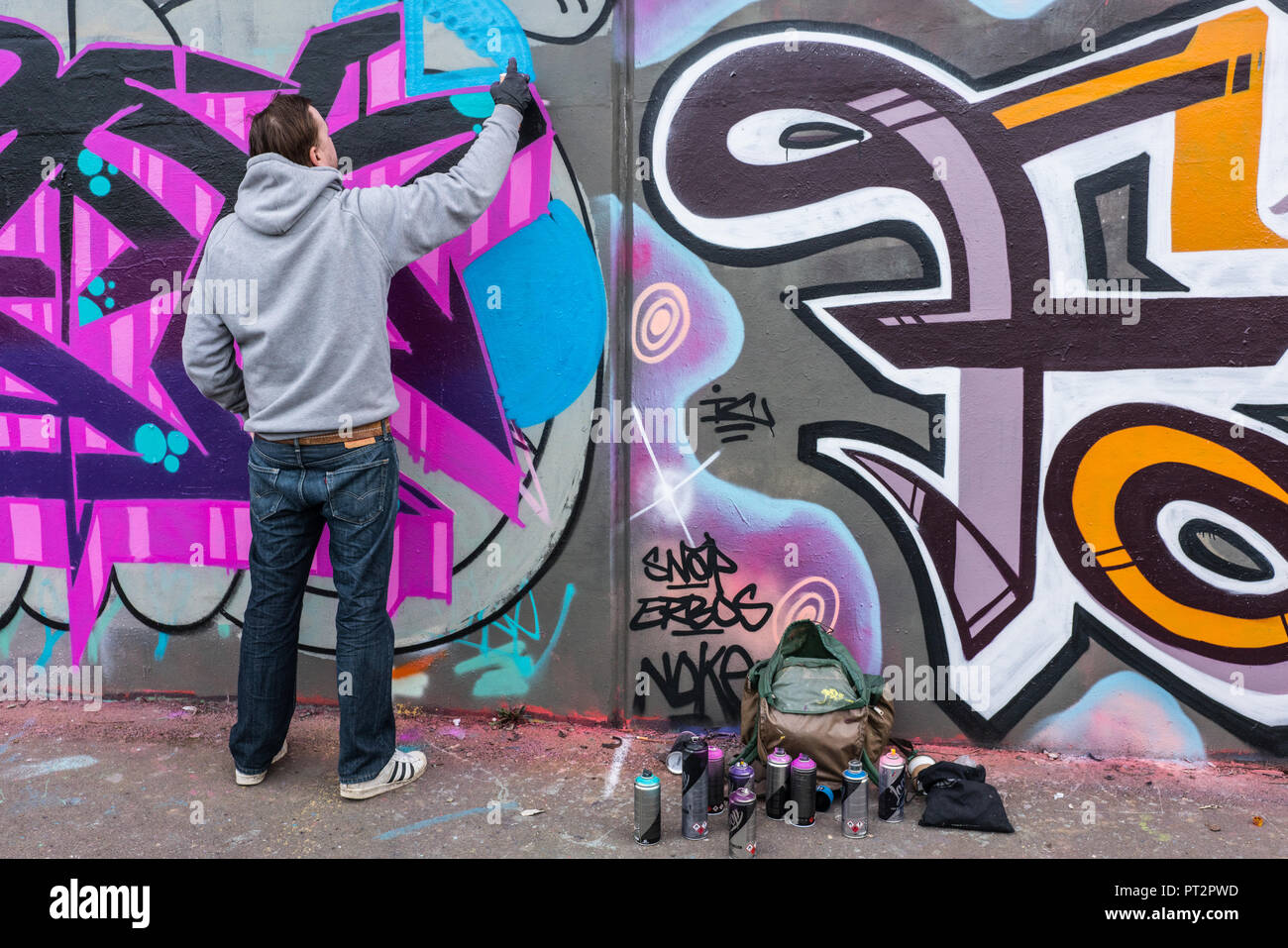 Street artists hard at it creating fresh work in the Brick Lane area of East London, UK. The area is a feast for creatives with new pieces daily Stock Photo