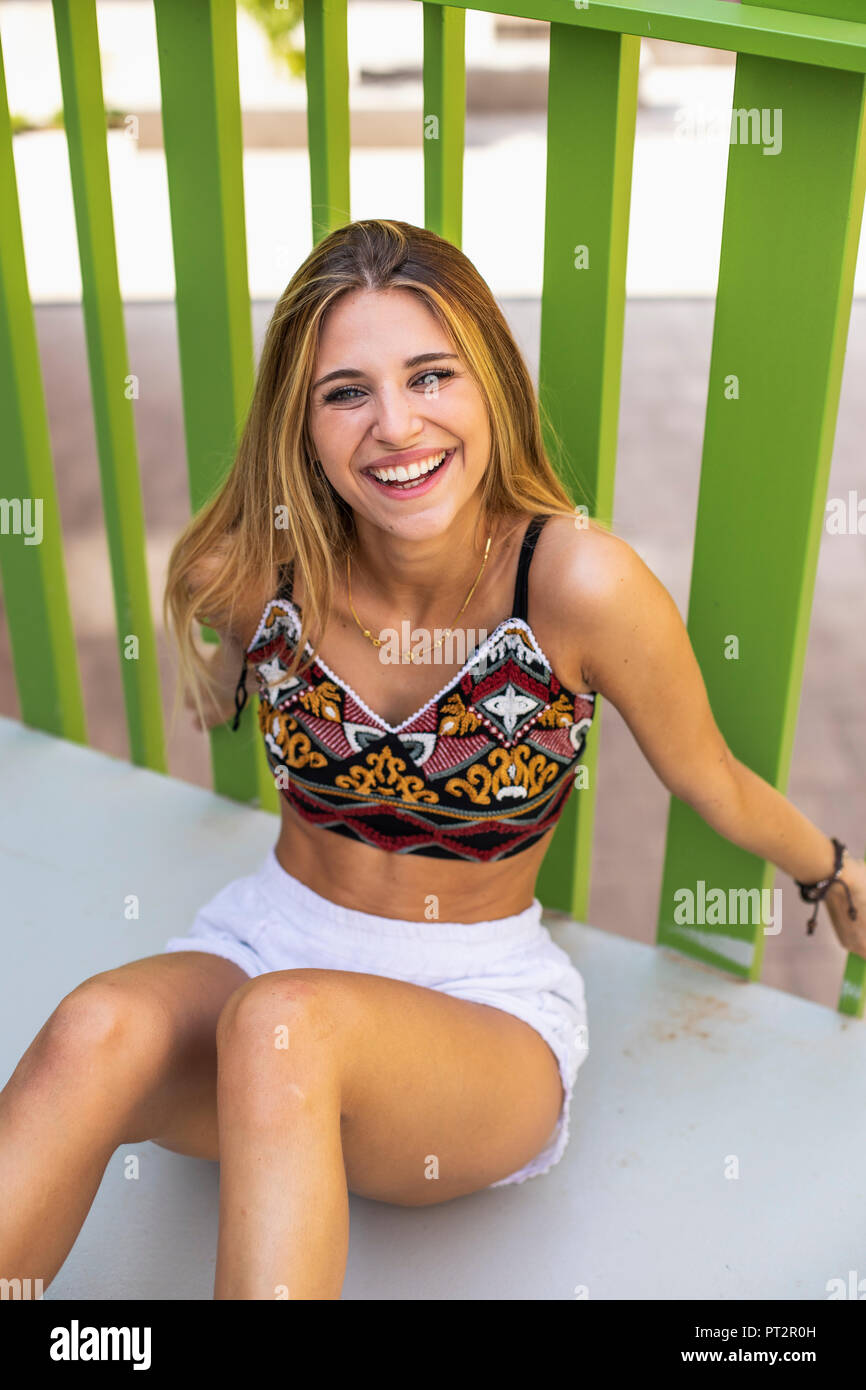 Pretty blond young woman, sitting,  smiling Stock Photo