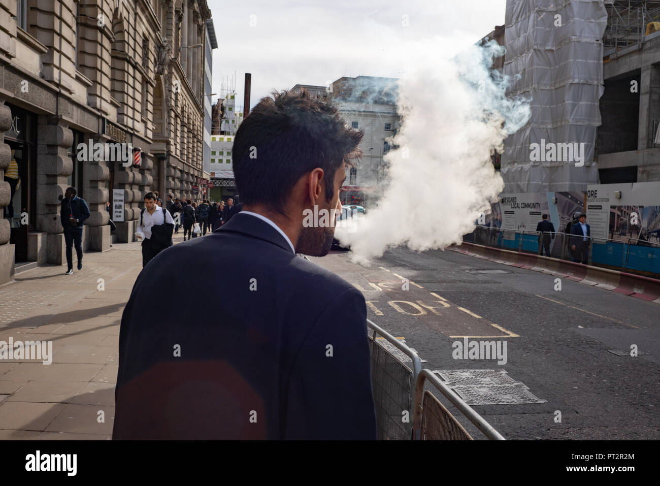 Exhailing Vape creates a lot of smoke. London, UK Stock Photo