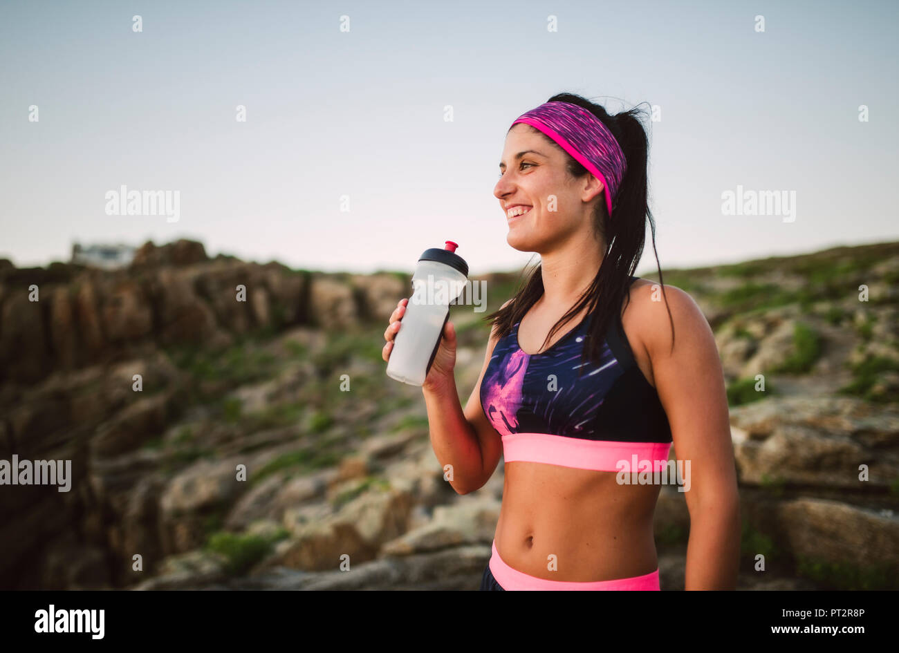 Portrait of an athlete woman drinking water outdoors Stock Photo