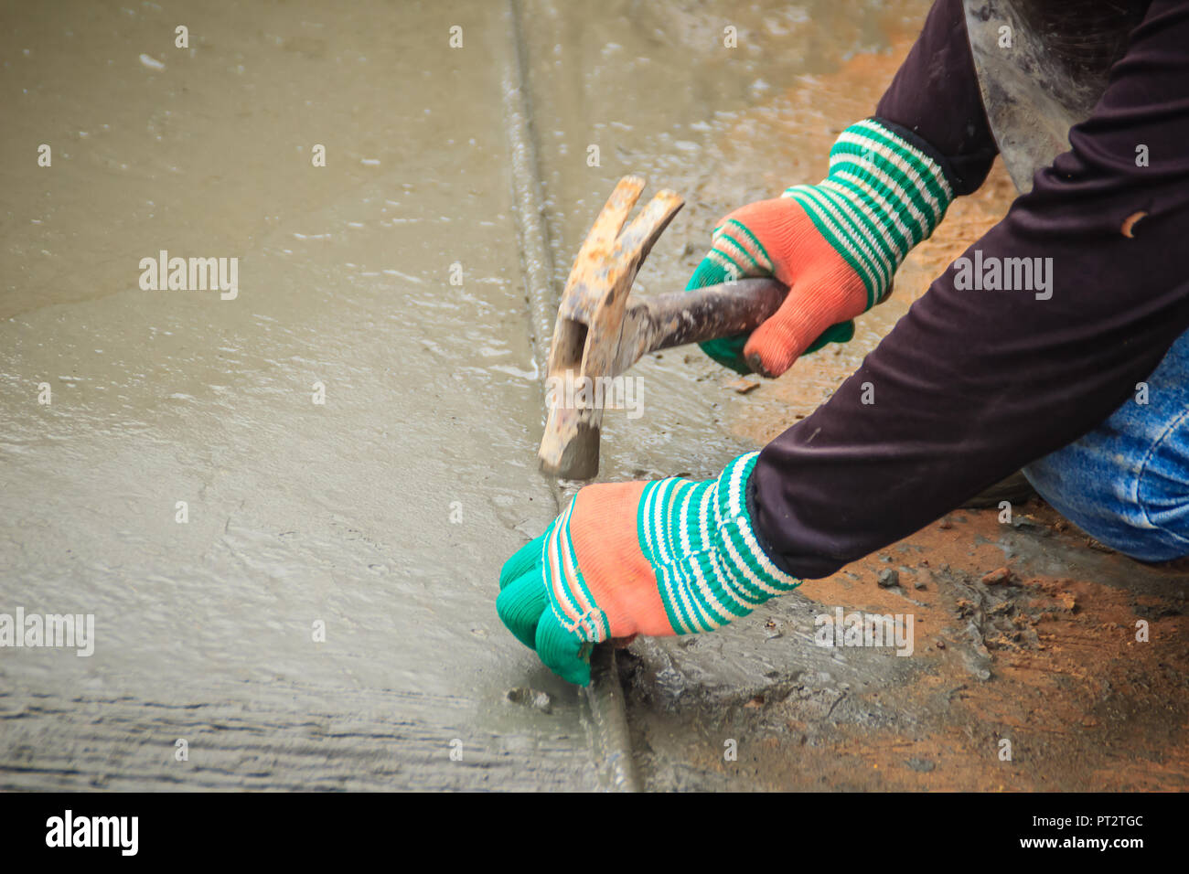 Grooving on concrete pavement by worker used deformed steel bar to