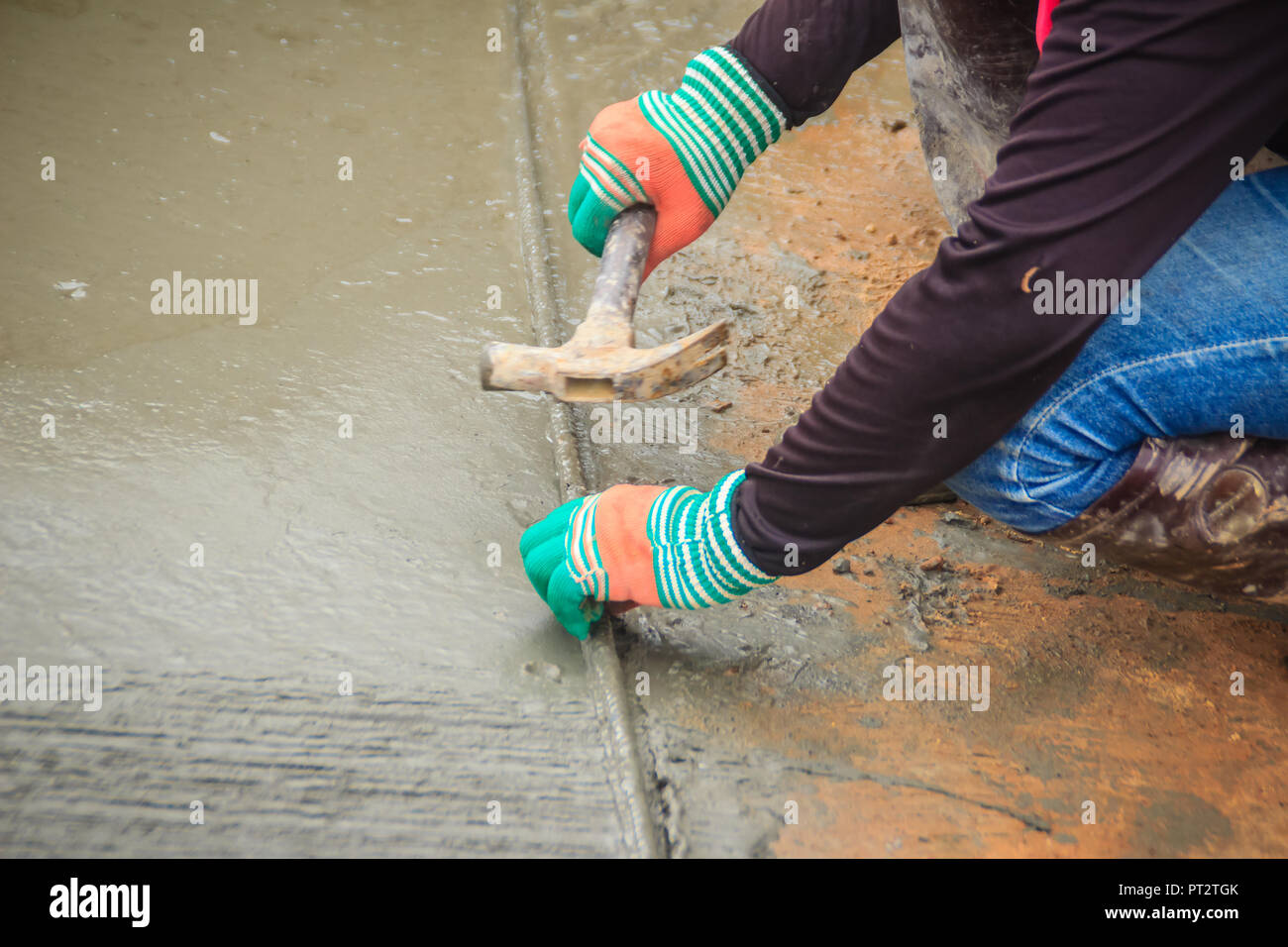 Grooving on concrete pavement by worker used deformed steel bar to stamp on concrete surface