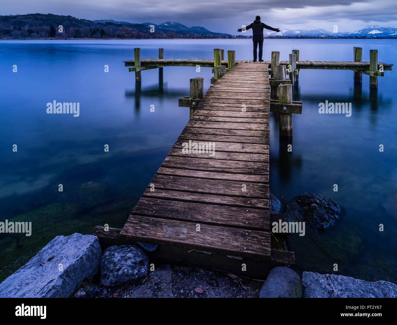 Meditative mood on the lake shore, man on jetty Stock Photo