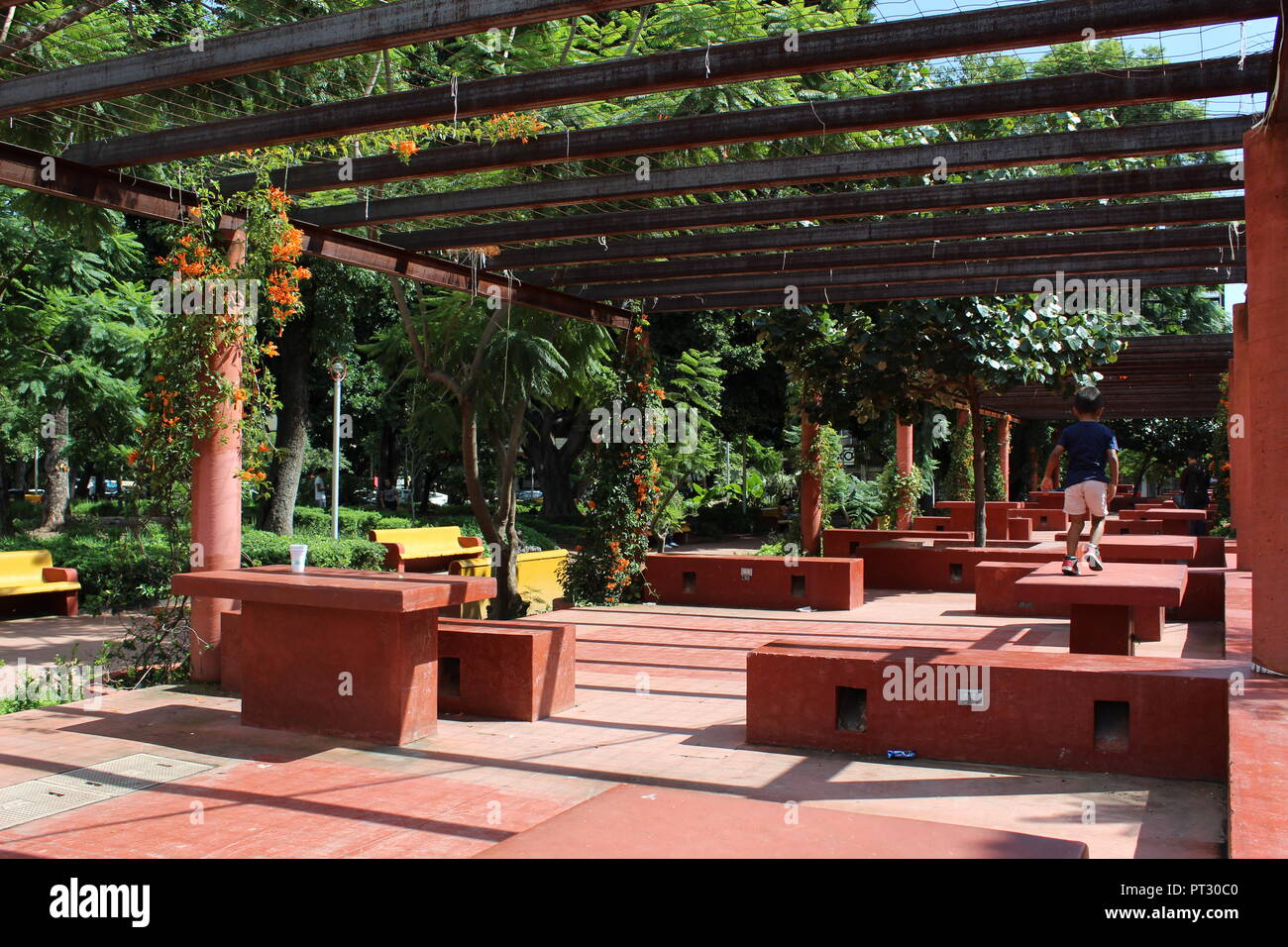 parque rojo en Guadalajara ubicado en avenida Vallarta y avenida Federalismo zona de descanso con mesas y bancas en color rojo decorado con enredadera Stock Photo