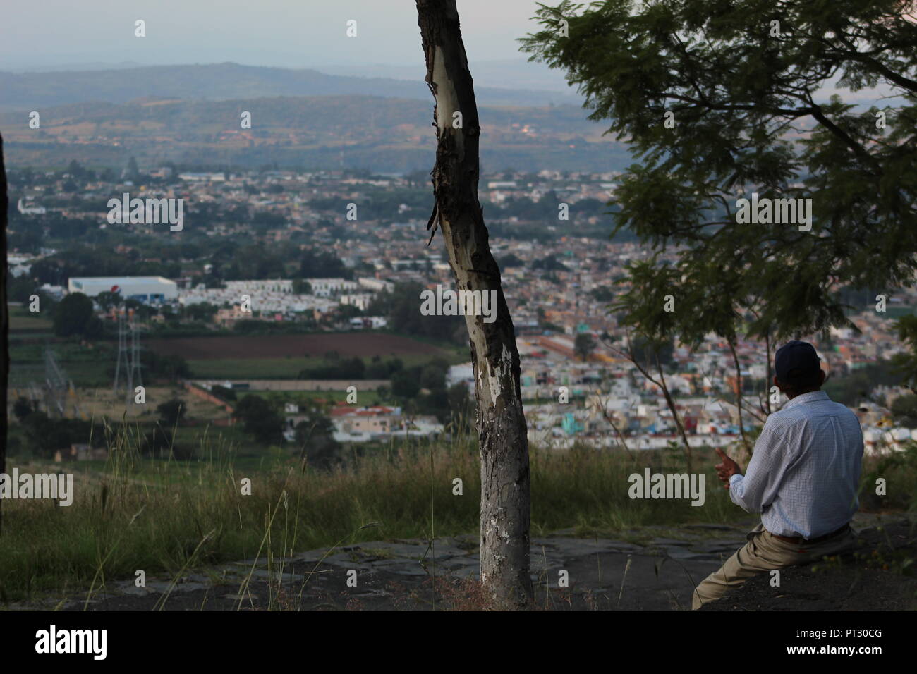 señor apreciando el paisaje desde el cerro de la reina en Tonala, vista panoramica de la barranca de Huentitan en un atardecer de la ciudad Stock Photo