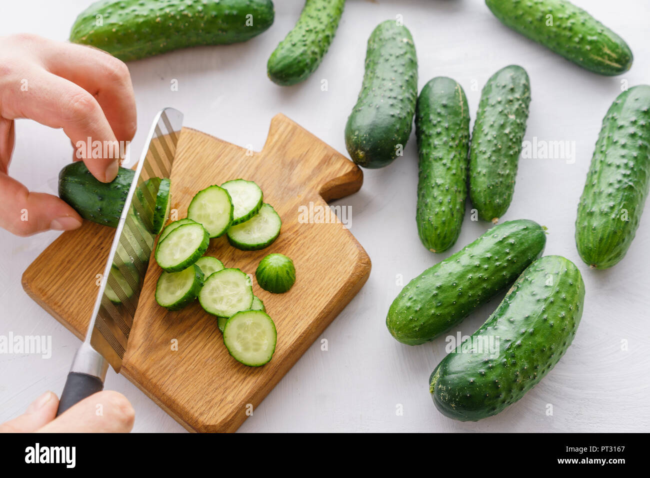 Mans hands cutting cucumbers for detox water. Top view. Process of