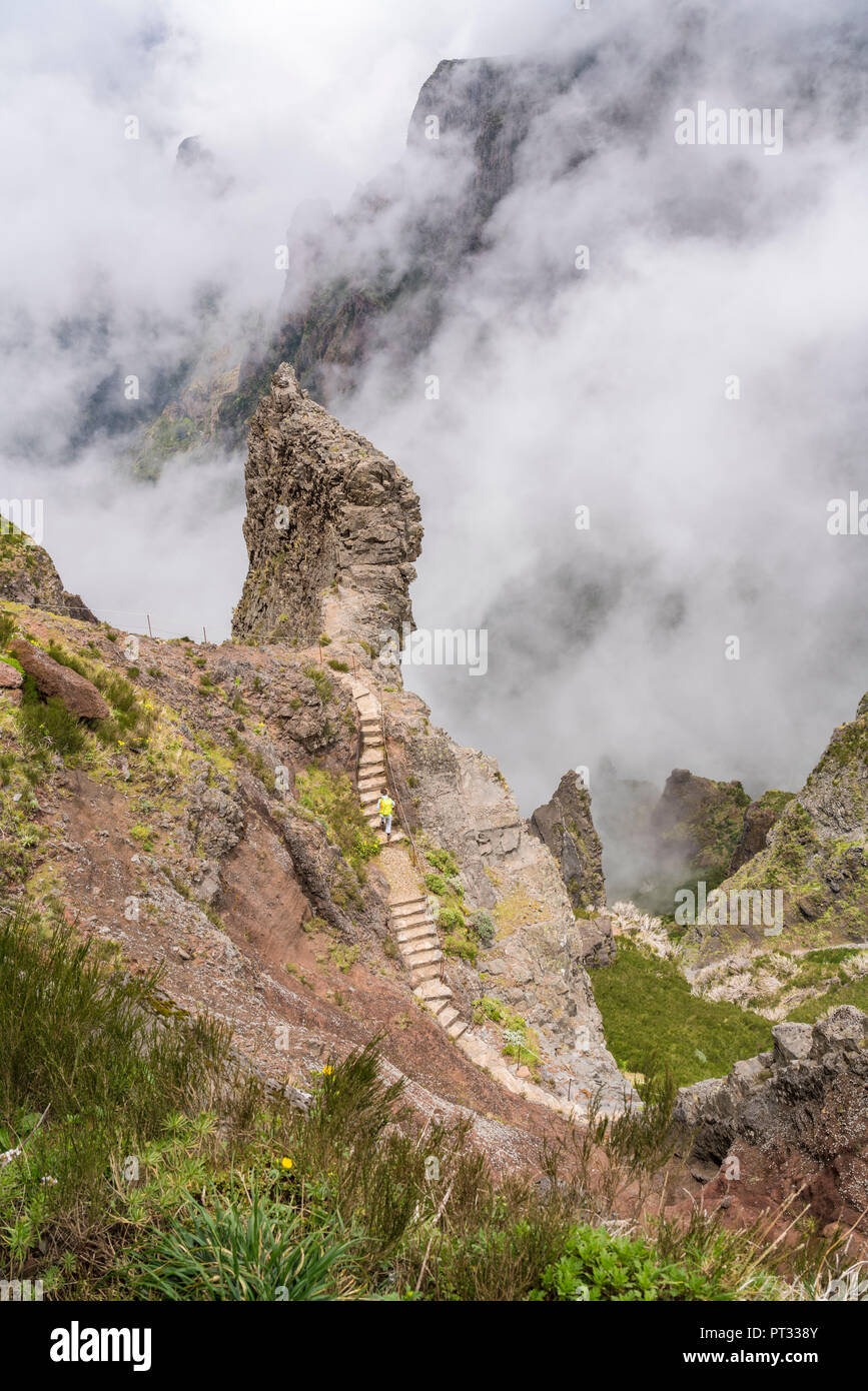 Person climbing up the steps on the trail at Pico do Areeiro, Funchal, Madeira region, Portugal, Stock Photo