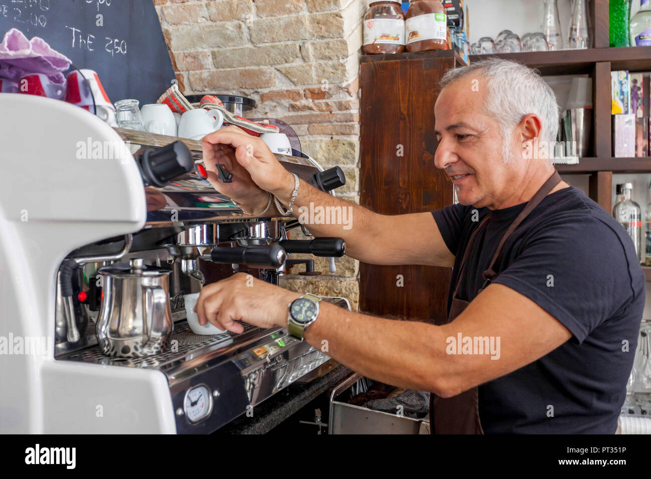Waiter waiting at espresso machine in an old cafe in Cagliari, Sardinia, Italy Stock Photo