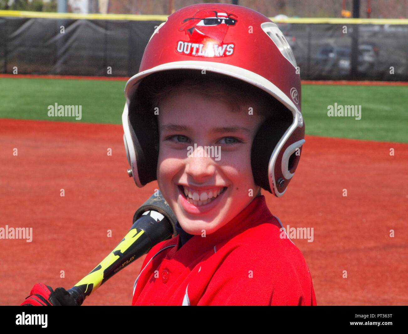 Young smiling Little League baseball player holding bat with his red helmet Stock Photo Alamy
