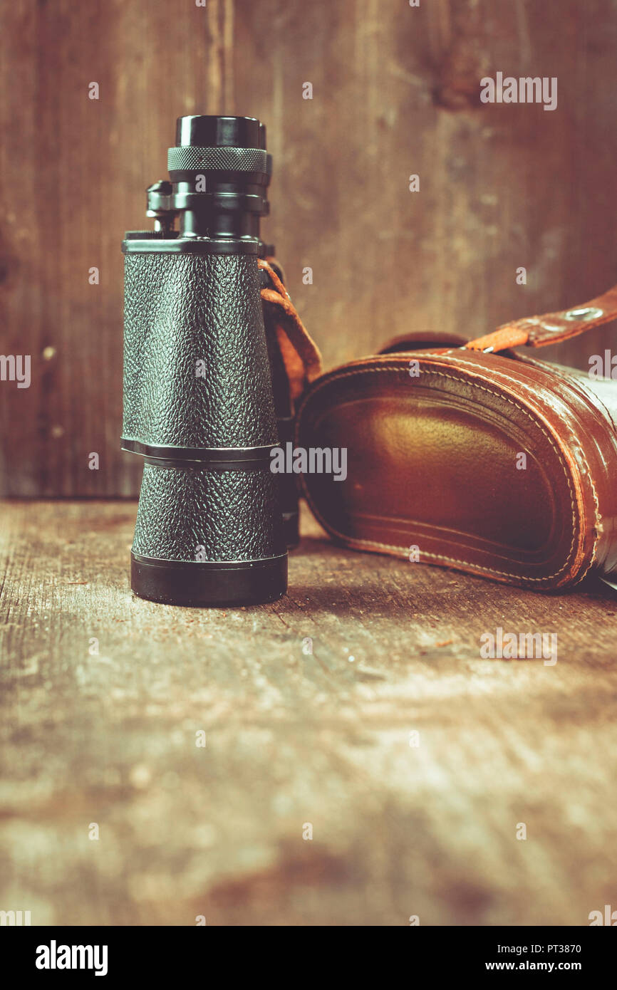 Binoculars and old leather bag lying on a table Stock Photo