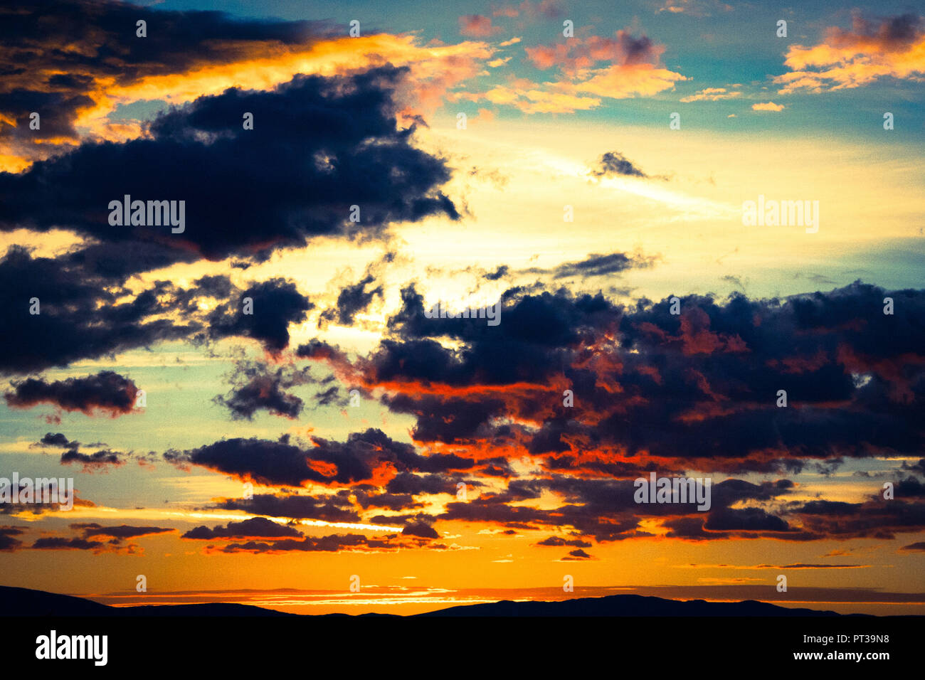 Cloudy sky with setting sun, play of colours, thunderclouds Stock Photo