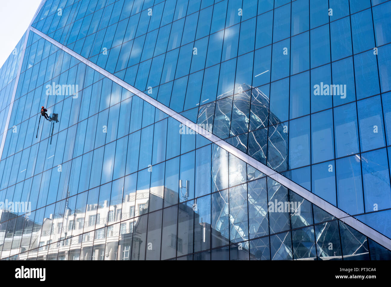Window cleaner abseiling down an office building in London. England Stock Photo