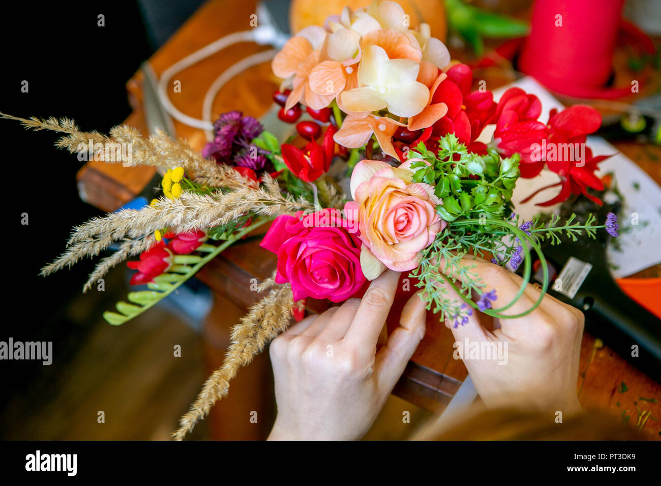 Female hands making beautiful bouquet of flowers on background Stock Photo