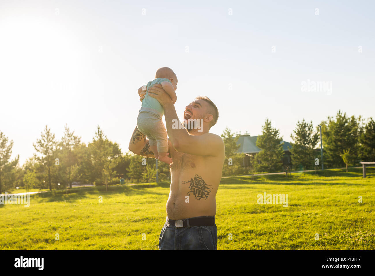 Happy father holding baby son, throwing baby in air. Concept of happy