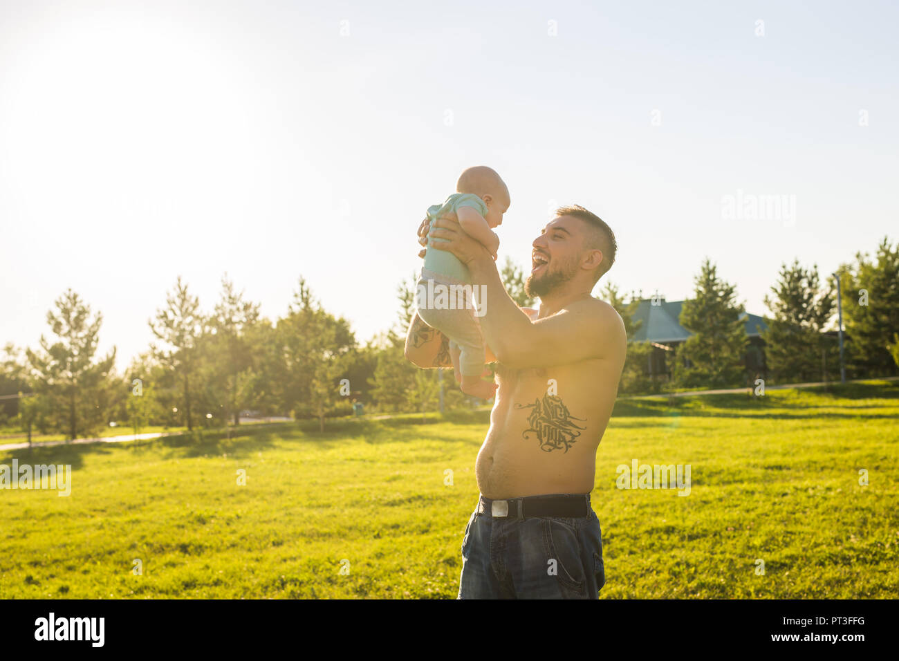Happy father holding baby son, throwing baby in air. Concept of happy